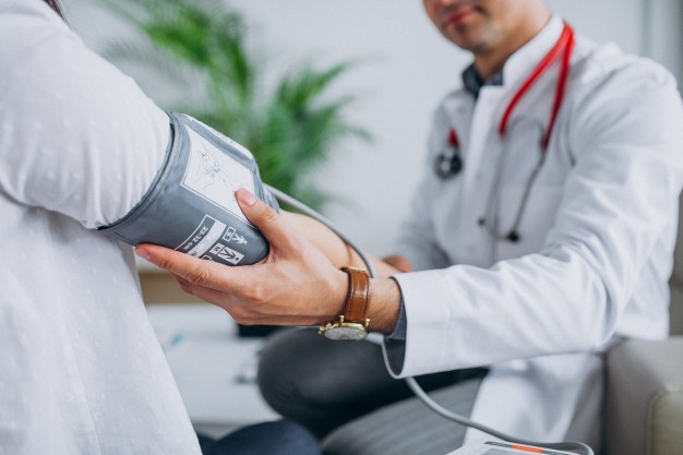 young-male-psysician-with-patient-measuring-blood-pressure_1303-17877